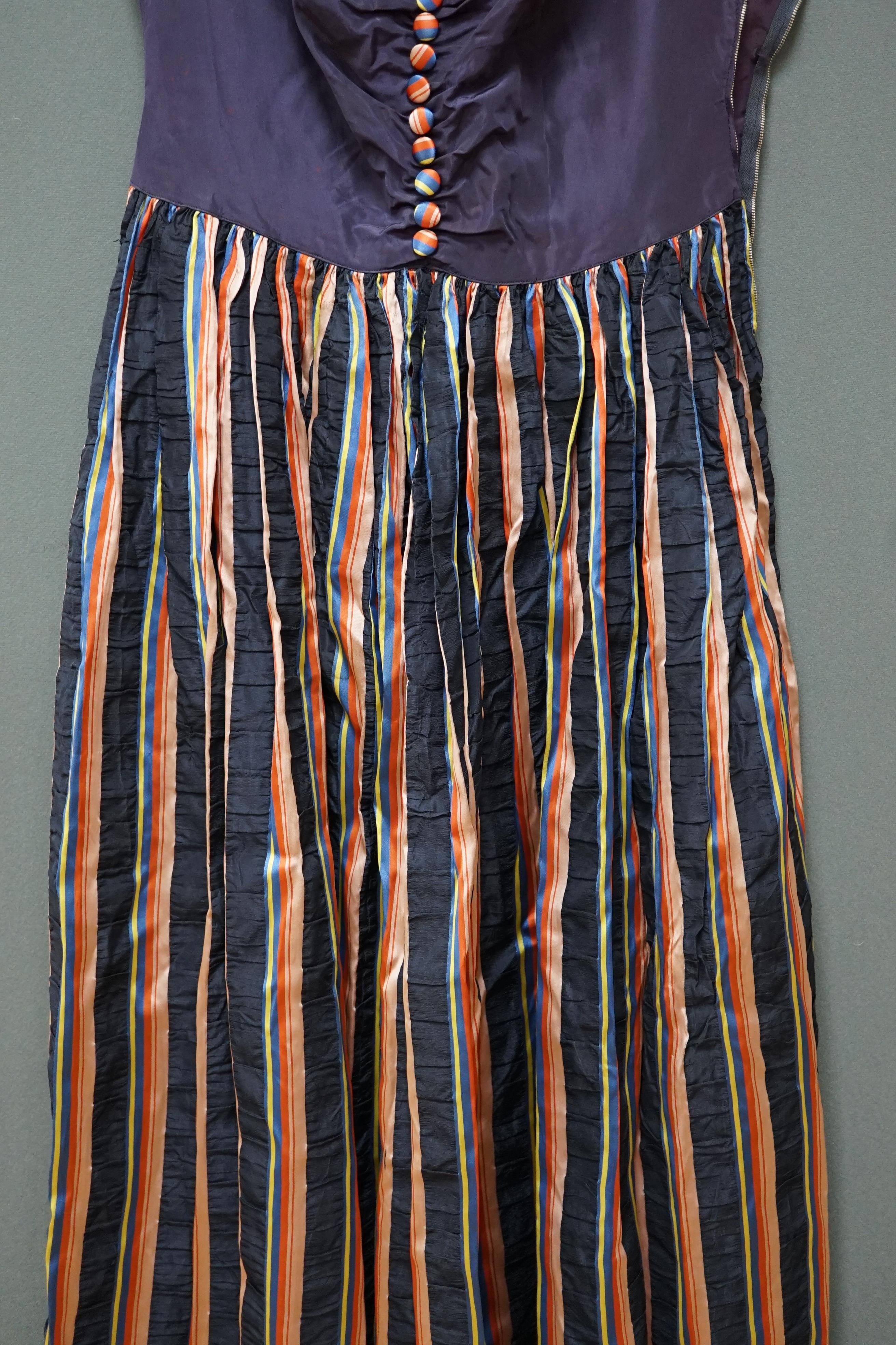 A 1940’s multi coloured striped silk and taffeta evening dress, designed with a blue taffeta bodice and colourful stripe gathered skirt, belt and back strapped yoke and matching buttons, 43cm front chest arm to arm. Cond